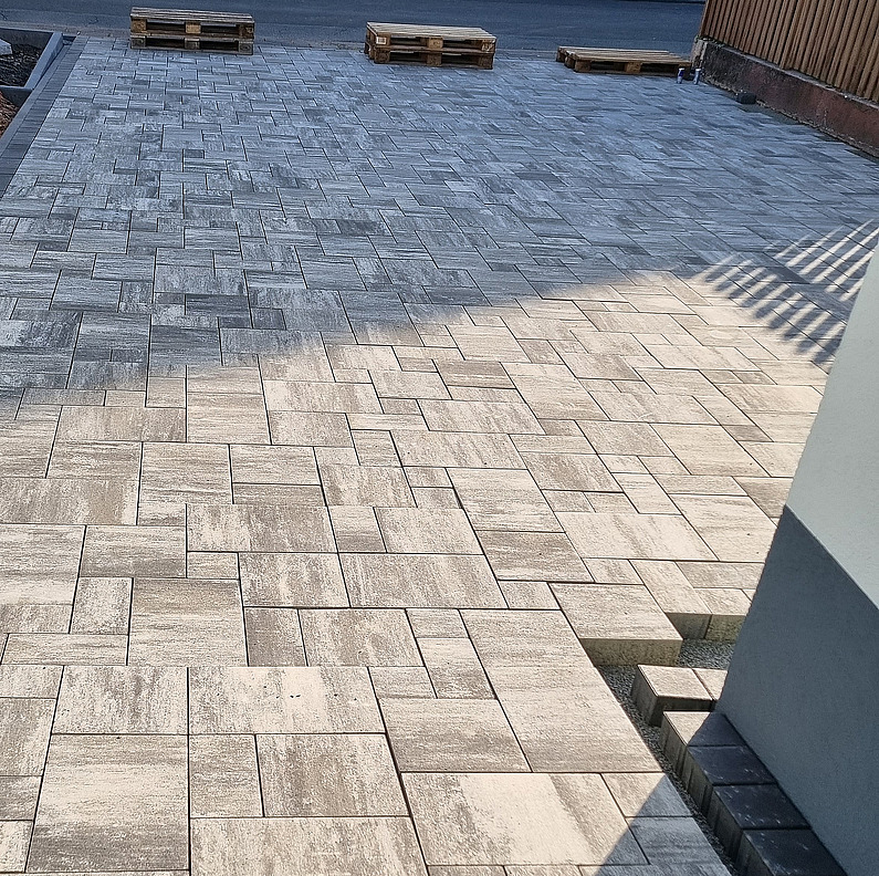 Neue graue Pflastersteine in einer Hauseinfahrt.