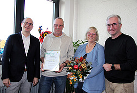 Bürgermeister Jörg Rotter und Till Andrießen von der Wirtschaftsförderung ehren das Ehepaar Löbig.