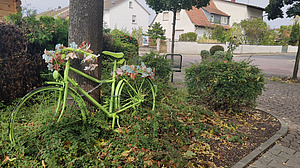 Grünes Fahrrad im Beet