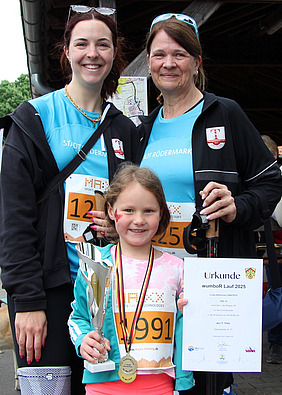 Kleine Siegerin mit Urkunde und Pokal