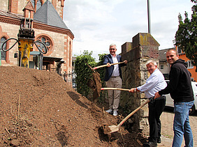 Symbolischer erster Spatenstich am Erdaushub vor der Kirche St. Nazarius.