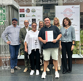  Rita Schrod, Till Andrießen, Leiter der Wirtschaftsförderung der Stadt Rödermark (Dritte und Zweiter von links), Vinzenz Schrod im Vordergrund mit Urkunde.