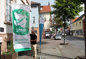 Bürgermeister Jörg Rotter mit der Flagge der Mayors for PEace 2022