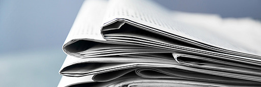 Nahaufnahme eines gefalteten Zeitungsstapels mit sichtbaren Papierkanten